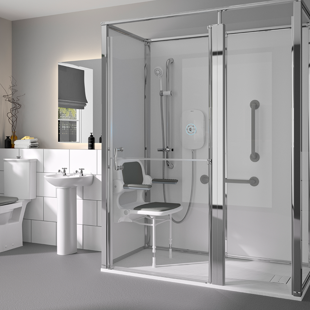 A bright, modern wet room conversion featuring a level-access shower area with a fold-down shower seat and grab rails, a pedestal sink, and a toilet.