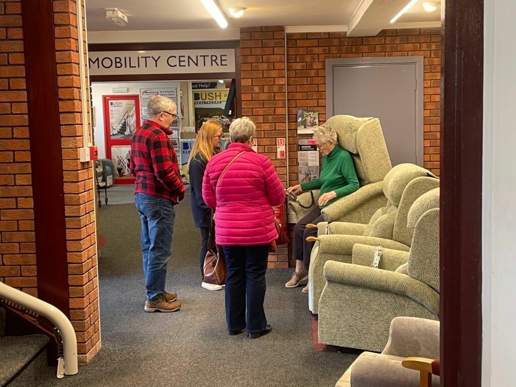 Alison assisting customers with riser recliner chairs in Aberdare store.