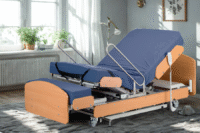 A modern adjustable profiling bed in a home setting, featuring wooden head and footboards and integrated side rails.