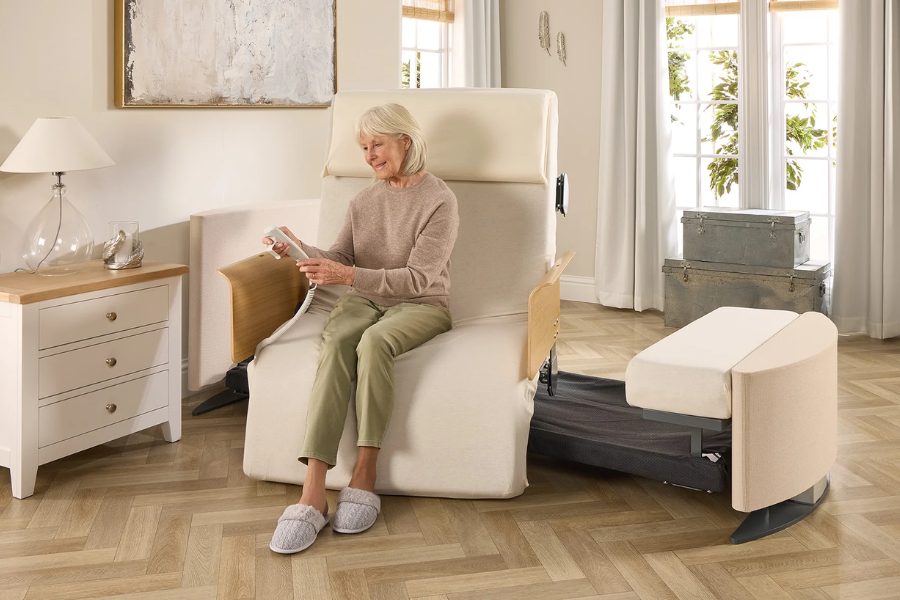 Elderly woman sitting comfortably on an Opera Roto Bed as it assists her with standing up.