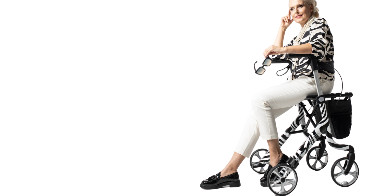 Space LX Art Line Rollator Lifestyle Picture in Zebra Print, demonstrating a lady sat in the rollator.