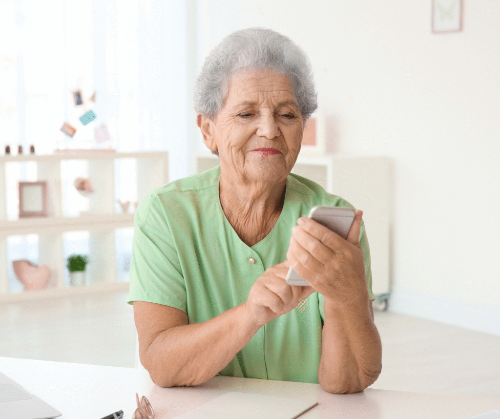 Elderly person using smartphone for Bush Healthcare aftercare support.