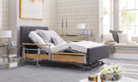 The Opera Solo Comfort Plus adjustable bed, single size, articulated with the head and knees elevated, showcasing the profiling feature and luxury design in a modern bedroom.