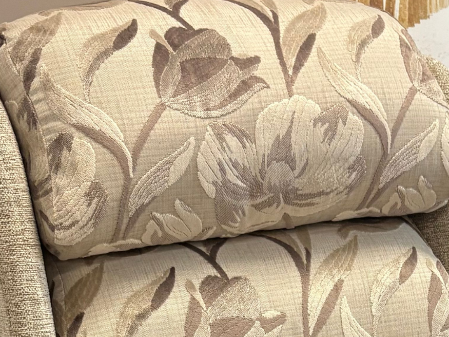 Close-up of a decorative back on a riser recliner chair, featuring a beige and brown patterned floral fabric.