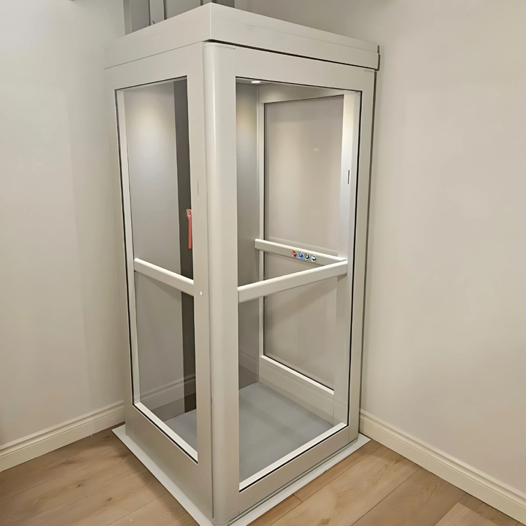 White, glass-enclosed Pollock indoor vertical lift installed flush within a standard wall opening with light wood flooring.