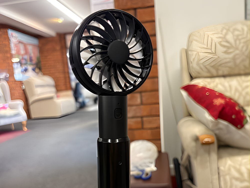 Black personal fan, ideal cooling accessory for users of riser recliner chairs.