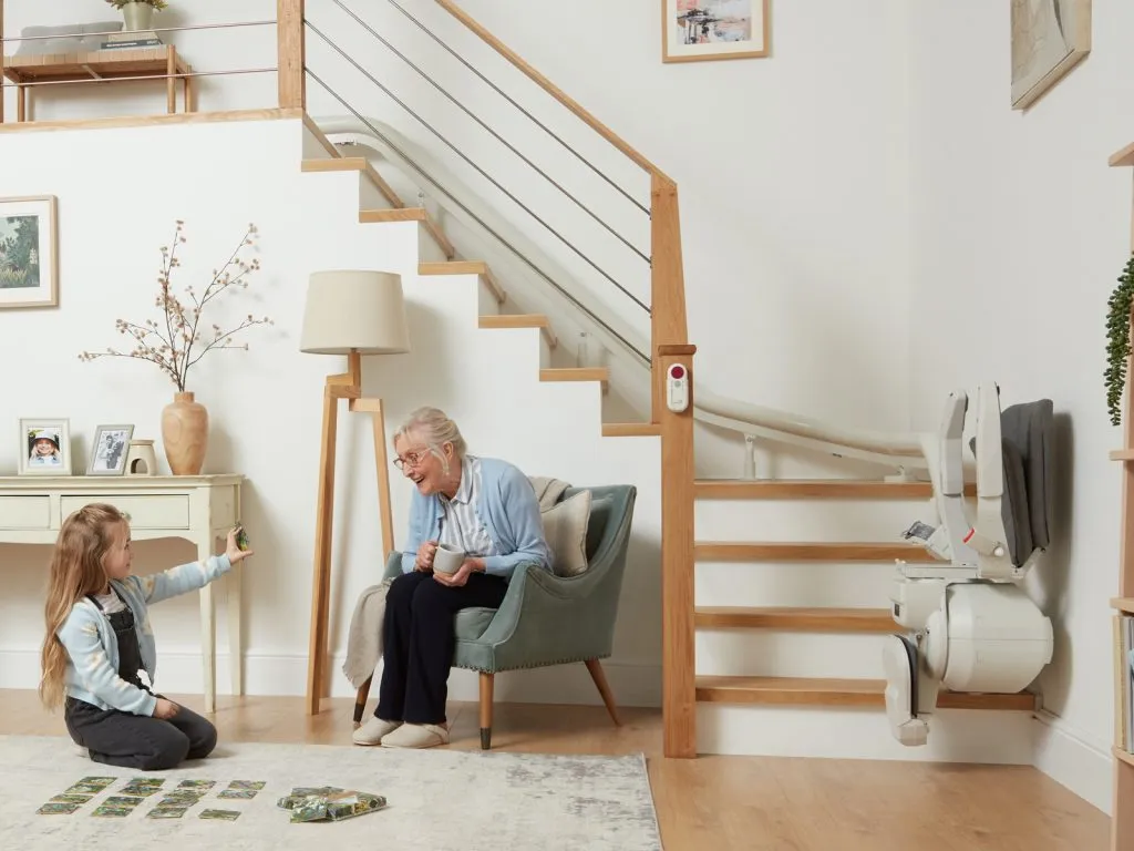 Couple in a living room beside a curved stairlift on a turning staircase